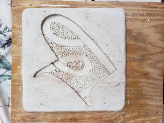 Photo of a shape etched for printmaking on wood.