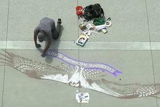 Aerial view of a person creating chalk art of a Bay Area Bird.