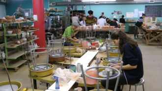 Students at pottery wheel.