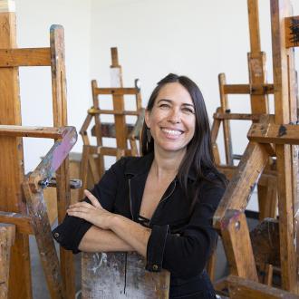 Juniper Harrower, smiling and sitting around easels