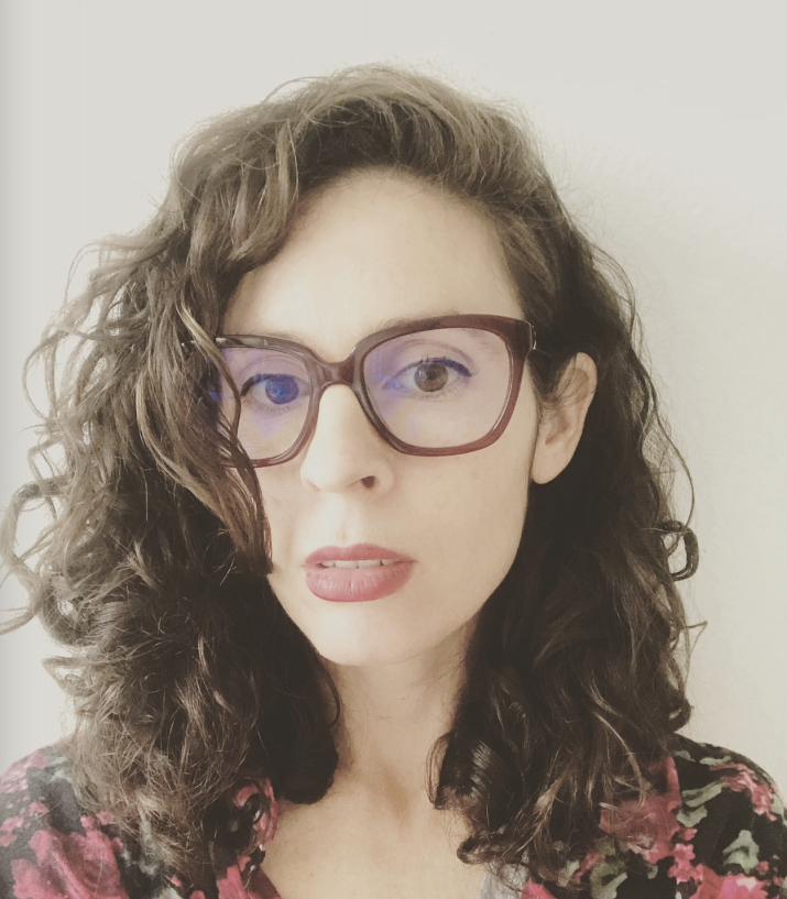 Alexandra Saum-Pascual, wearing brown glasses, poses for a portrait.