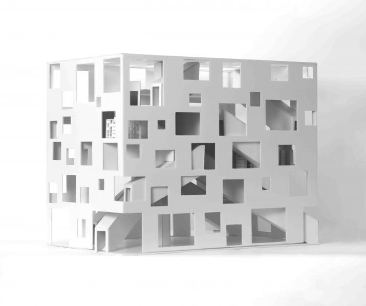 A square building with different sized squares cut into it and scattered about. Staircase tunnels on the inside.
