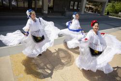 UC Berkeley students in white dresses dancing Ballet folklorico.